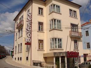 a building with a sign on the side of it at Hotel Botanico de Coimbra in Coimbra