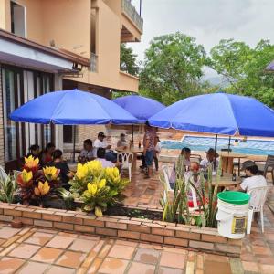a group of people sitting at tables under blue umbrellas at BONANZA in Monterrey +23 photos