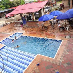 una piscina con 2 personas nadando en ella con sombrillas en BONANZA, en Monterrey