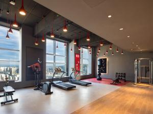einen Fitnessraum mit Laufbändern und Trainingsgeräten in einem Gebäude in der Unterkunft Radisson RED Hotel Zhuhai Gongbei Port in Zhuhai