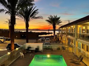 a house with a swimming pool and palm trees at Sway Hotel in Lake Havasu City