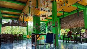 Green Forest Tangkahan في Tangkahan: مطعم بجدران وطاولات خضراء وصفراء