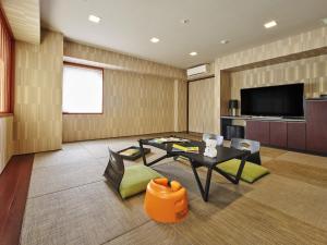 uma sala de estar com uma mesa e uma televisão em Village Kyoto em Quioto