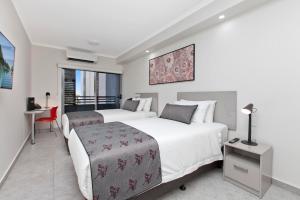 Un pat sau paturi într-o cameră la Argus Hotel Darwin