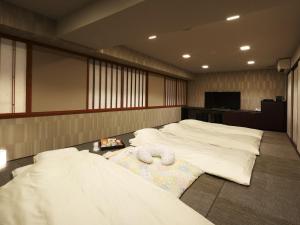 um quarto com duas camas com toalhas no chão em Village Kyoto em Quioto