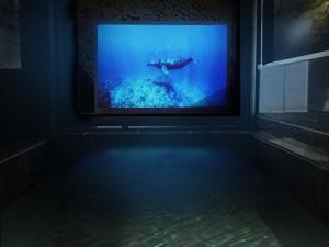 a tv in a room with a bath tub with water at KIYOMORI in Hatsukaichi