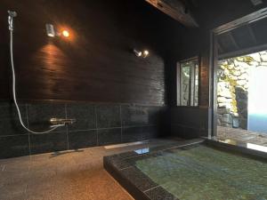 a bathroom with a bath tub with a shower at KIYOMORI in Hatsukaichi
