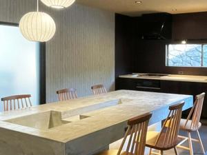 a kitchen with a large marble table and chairs at KIYOMORI in Hatsukaichi