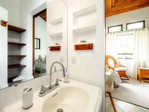 a bathroom with a sink and a mirror at Villa Corazón - private beach at Lake Arenal in Nuevo Arenal +87 photos