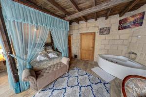 a bathroom with a tub and a bed in it at Cappadocia Alaz Cave Otel in Nevşehir