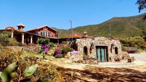 una gran casa de piedra frente a una montaña en Viña Calabria en Valle de Guadalupe