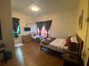 a room with a bed and a couch in it at BoraBora Beach Guesthouse Penang in George Town