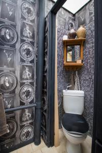 a bathroom with a toilet and a black and white wall at Cosy Central House with luxury jacuzzi bath in Hesdin