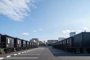 una larga fila de contenedores negros en una calle en HOTEL R9 The Yard Asahishiro, en Asahi