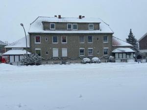 a large brick house with snow on the roof at FeWo Zum Panscheberg in Salzgitter