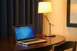 a laptop computer sitting on a desk with a lamp at ANA Crowne Plaza Okayama, an IHG Hotel in Okayama