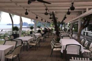 a row of tables and chairs under a pavilion at Norjannah Homestay @Regency Tg Tuan Beach Resort in Port Dickson