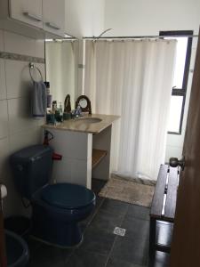 W łazience znajduje się niebieska toaleta i umywalka. w obiekcie Estrella de Mar w mieście La Paloma
