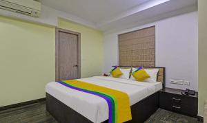 ein Schlafzimmer mit einem großen Bett mit einer bunten Decke in der Unterkunft Itsy By Treebo - Reotel in Kalkutta
