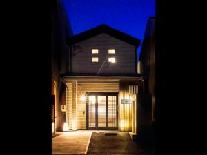 una casa iluminada por la noche con un garaje en Samurai House en Nagoya