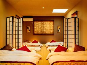 ein Zimmer mit 4 Betten in Folge mit einem Zimmer mit in der Unterkunft Samurai House in Nagoya