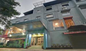 um edifício cinzento com uma frente de loja com uma escada em Treebo Trend Paradise Premium Rasulgarh em Bhubaneshwar