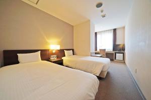 Postel nebo postele na pokoji v ubytování Chisun Hotel Kamata