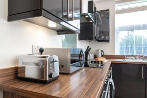 a kitchen with a counter top with a toaster at Silver Moon Silver Service Apartments Freeparking in Southampton