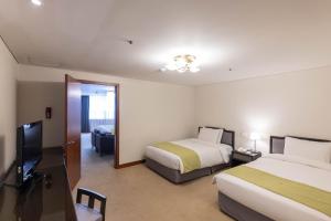 فندق بريزيدنت في سول: غرفة فندقية بسريرين وتلفزيون بشاشة مسطحة