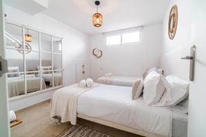 a white bedroom with two beds and a mirror at Sweet Inn - Villa La Sala in Marbella