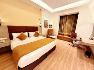 a hotel room with a large bed and a desk at Best Western Vrindavan in Vrindāvan