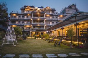 a large building with benches in front of it at Hotel Crown Himalayas in Pokhara
