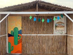 a building with a cactus and a painting on the wall at Alwaha Camp in Nuweiba