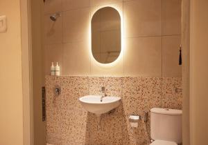 a bathroom with a sink and a toilet and a mirror at Villa Rone By The Villas 100 in Bogor +45 photos
