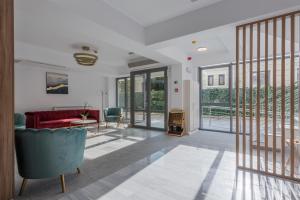 a living room with a red couch and glass doors at Aparthotel Pietroasa in Buzău