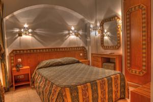 a bedroom with a bed and a mirror at Real Caparica Hotel in Costa da Caparica