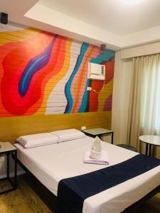 1 dormitorio con 1 cama con una pintura en la pared en Sultana Ysabella Hotel and Event en Manila