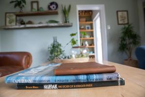 einen Stapel Bücher auf einem Tisch in der Unterkunft Cape Cottages in Bergvliet