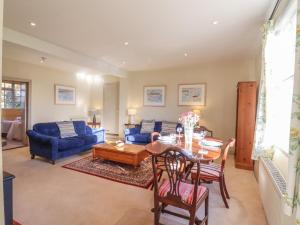 een woonkamer met een tafel en een blauwe bank bij The Garden Flat at Holbecks House in Hadleigh