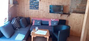 a living room with a blue couch and a table at Zirbenhütte in Hohentauern