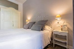 ローマにあるVaticano Charming Roomsのベッドルーム(白い大型ベッド、ランプ2つ付)