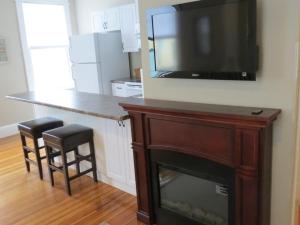 a kitchen with a stove and a television at Drydock Cafe & Inn in Southwest Harbor