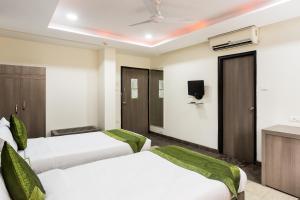 a hotel room with two beds and a tv at Treebo Trend Fort Club in Hyderabad