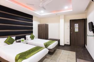 a hotel room with two beds and a tv at Treebo Trend Fort Club in Hyderabad