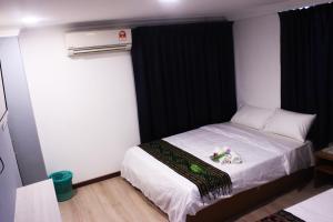 Un pequeño dormitorio con una cama con flores. en Kapit Hotel, en Kuching