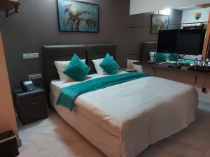 a bedroom with a bed with a desk and a television at Dhimyaath Stay in Male City