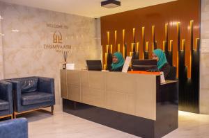 two women sitting at a reception desk in a lobby at Dhimyaath Stay in Male City