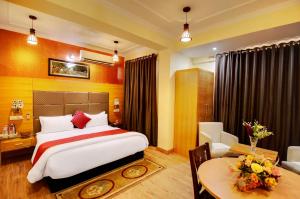 1 dormitorio con cama, escritorio y mesa en The Grand Mamta, en Srinagar