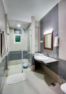 y baño con ducha, lavabo y espejo. en The Grand Mamta, en Srinagar