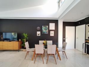 a dining room with a glass table and white chairs at Elle Ocean Villa Gran Canaria Heated pool Wifi in Amadores